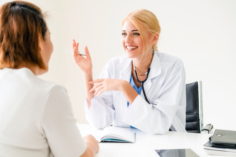 Woman Doctor and Female Patient in Hospital Office
