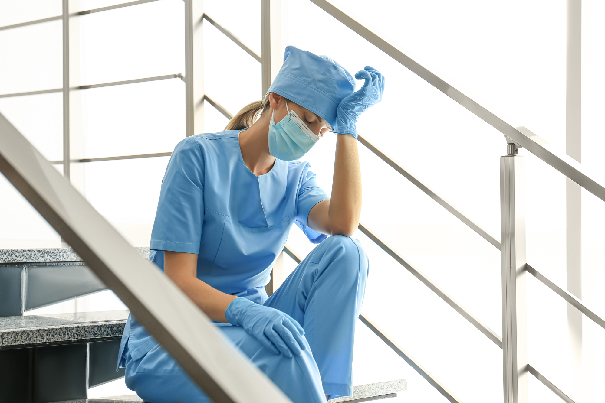 Hospital worker in scrubs stressed out