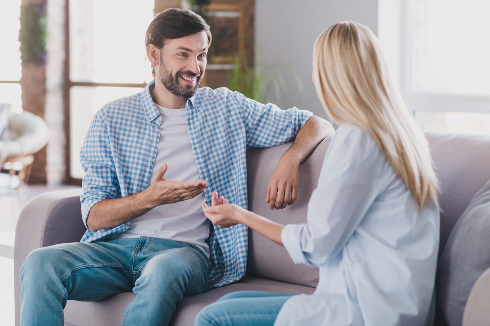 Photo of positive cheerful two people have relaxing conversation wear casual outfit in comfortable home indoors UNISON Rehab facade - Inpatient mental health treatment near Belmont Behavioral Health System.