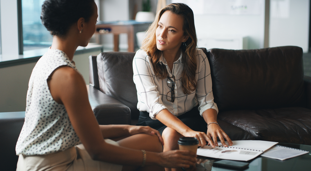 Working together to find a solution. two businesspeople having a discussion while sitting on a couch in a modern office. Adult patients with obsessive-compulsive disorder.