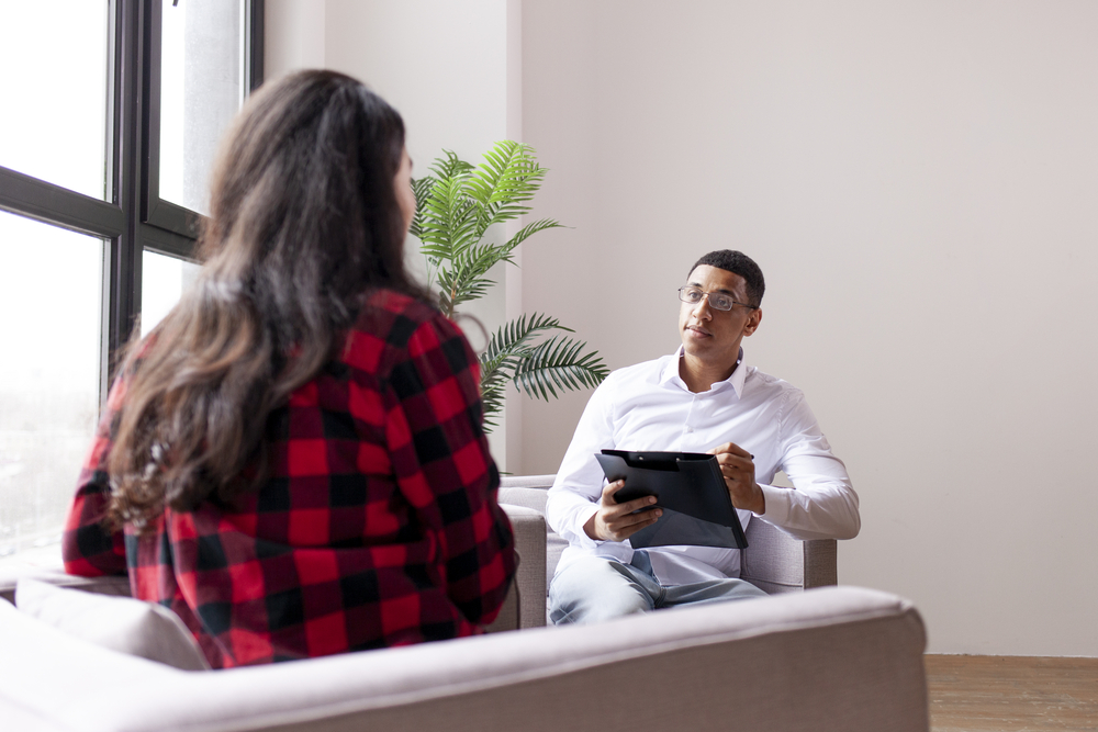 session with psychologist, woman patient sits in psychologist’s office and tells her problems